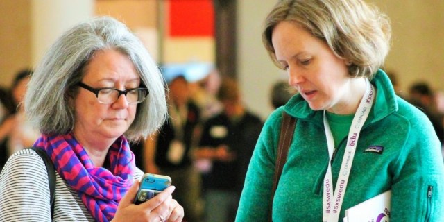 SXSW EDU 2017 attendees checking the mobile app. Photo by Nicole Burton.