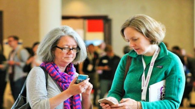 SXSW EDU 2017 attendees checking the mobile app. Photo by Nicole Burton.